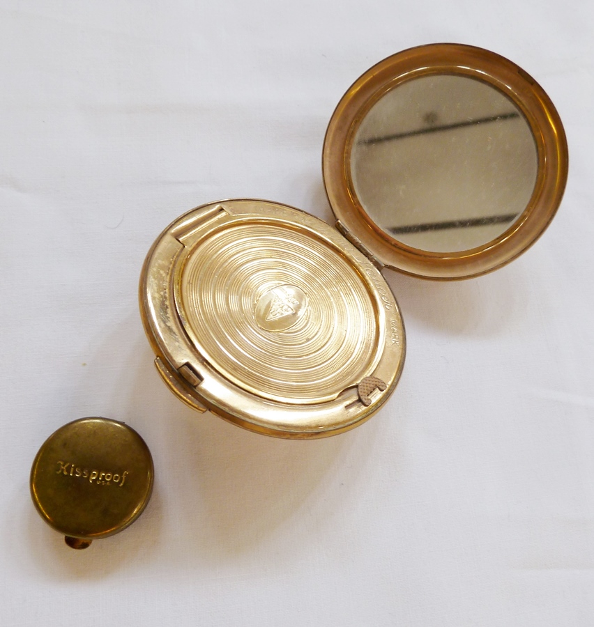 Kigu gilt metal compact, in the form of flying saucer, and small "Kissproof" lipstain