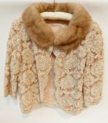 1950s evening jacket, ribbon lace over peach-coloured silk, with a mink collar, the label reads "