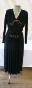 A 1930's black crepe dress, pintucks with pink crepe inserts and buttons, the belt with ribbon