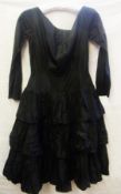 A Polly Peck black silk cocktail dress c 1955,  with tiered skirt, scoop neck with a 'v' back ,