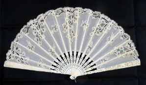 Ivory and lace fan, the sticks inlaid with metal sparkles and having cream lace, pierced bone and