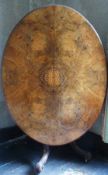 Victorian figured walnut quarter veneered tilt-top loo table, inlaid to centre, raised on carved and
