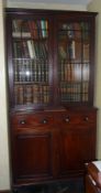 Late Regency mahogany bookcase on cupboard, the upper section enclosed by pair bar glazed doors over