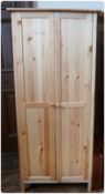 Modern pine double wardrobe, pair panelled doors enclosing hanging rail and single shelf on square