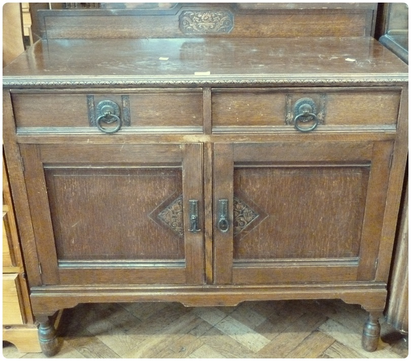 20th century oak sideboard, with two drawers above cupboards on turned supports, carved edges and