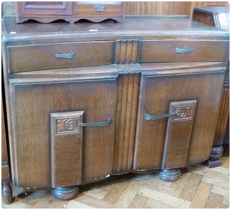 20th century oak sideboard with concave front, with two drawers and cupboards below, with carved