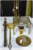 A pierced brass trivet stand together with a brass cup, brass candlesnuffers, ladle, fireside