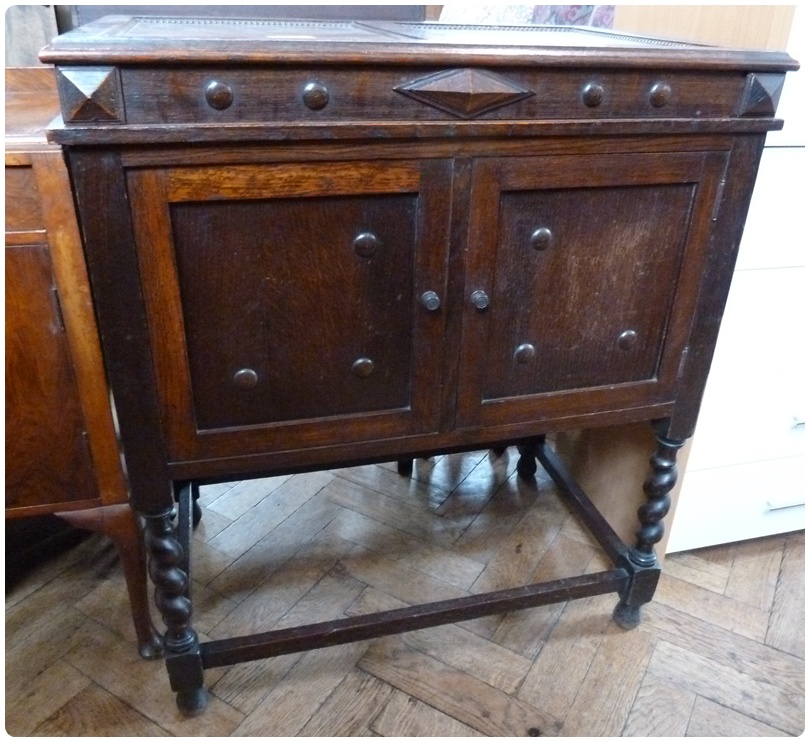 Twentieth century oak cabinet, with panel doors and carved circular decoration, on spirally twist