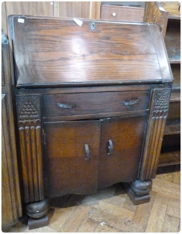 20th century oak bureau with leather inset fall front and pigeonholes, drawer and cupboard below,