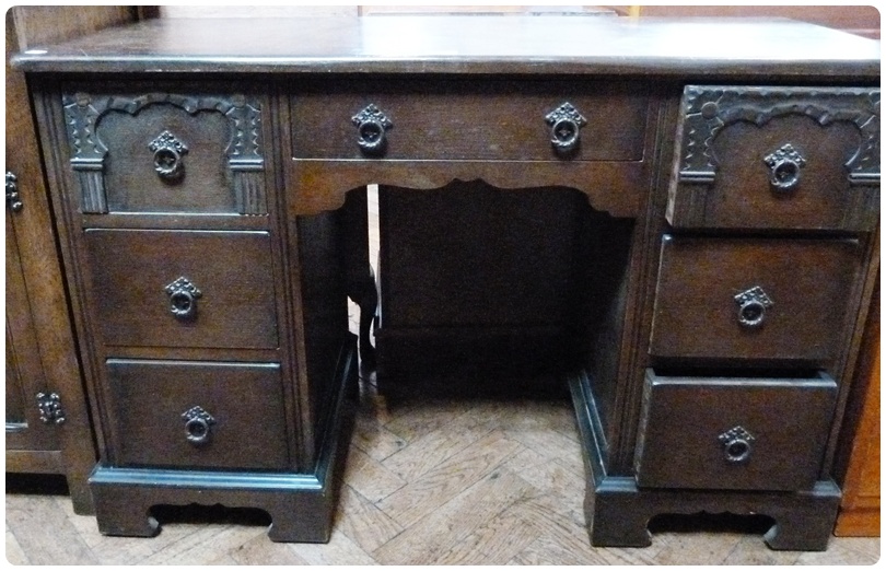 Modern stained oak kneehole desk, single frieze drawer and three small drawers to either side of the