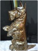 A cast iron gold lustre ware fire companion set, the holder in the form of a Highland terrier