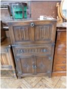 Reproduction carved oak drinks cabinet, the fall front revealing mirrored interior with adjustable