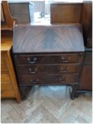 A reproduction mahogany bureau, with fitted interior, with three long graduated drawers on