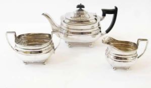 George V silver three-piece teaset of plain moulded form, raised on ball feet, comprising:-