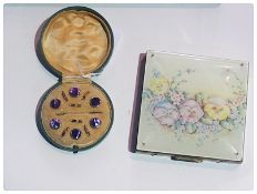 A square compact decorated with pansies, gold coloured and  purple dress studs in circular box (2)