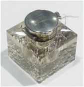 An Edwardian silver-capped square cut glass inkwell, the hinged cover with inset pocket watch,