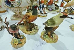 Three Royal Crown Derby tinted bisque model birds, "Green Woodpecker", "Bullfinch" and "Pheasant" (