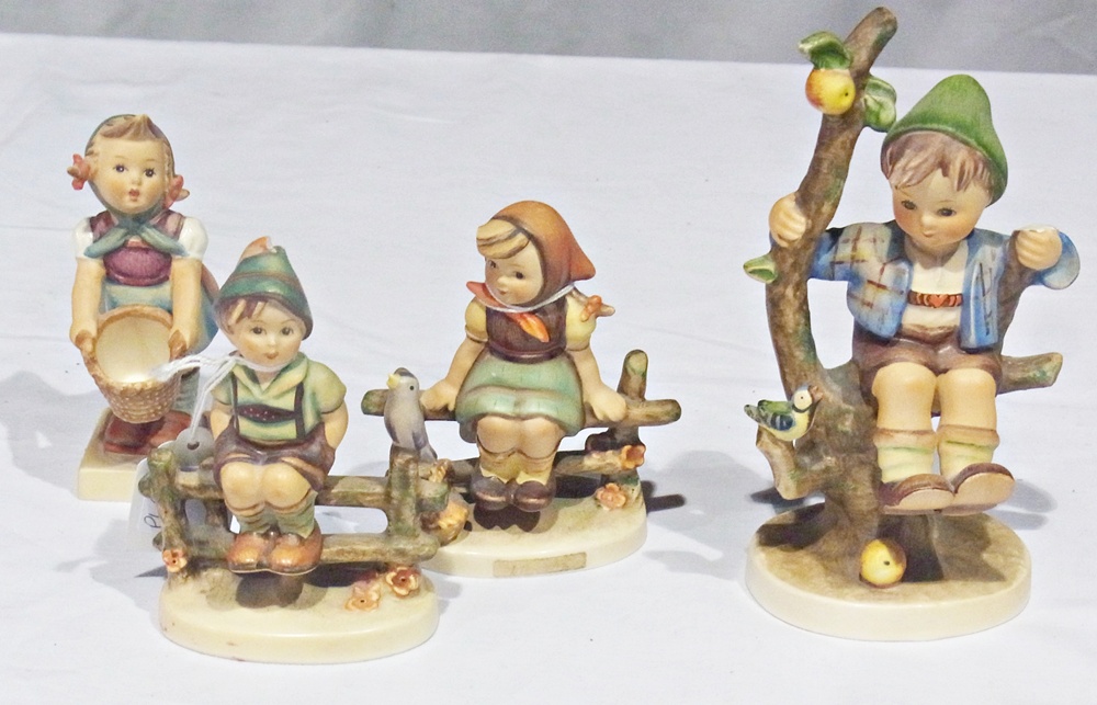 Four various tinted bisque Hummel figures of children, viz:- boy on apple tree, girl with basket,