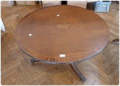 A reproduction mahogany circular top coffee table, inset with the Prince of Wales plumes, on