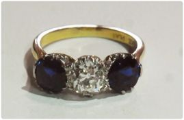 18ct gold and platinum three stone sapphire and diamond ring, set central circular diamond, 1.1/1.