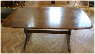 An Ercol refectory style dining table, on twin pedestal supports united by central stretcher,