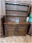 Reproduction stained oak 'Old Charm' style dresser, with open two shelf rack, two frieze drawers,