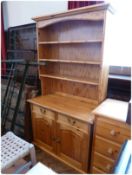 A modern pine dresser, with three shelf open rack, two frieze drawers and cupboards below, on plinth