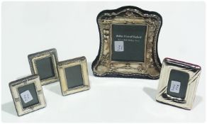 A rectangular silver photograph frame with trestle support, and four other silver photograph frames,