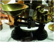 A set of iron kitchen scales with brass pans, and a series of ounce weights