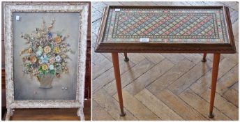 A glazed firescreen with dried flower arrangement panel, a Victorian glazed embroidery panel with