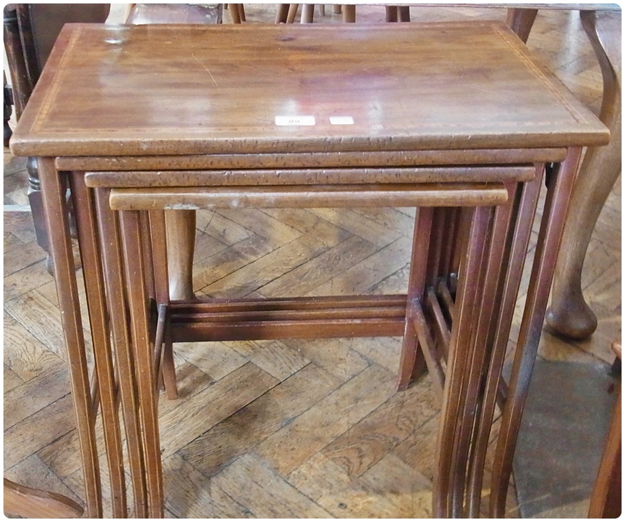 A nest of four mahogany and satinwood inlaid occasional tables, on turned tapering square legs, 58