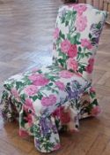 An upholstered bedroom chair in floral decorated fabric on square supports