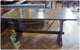 A reproduction oak refectory table, with pierced trestle supports united by central stretcher,