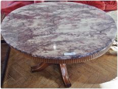 A marble circular topped coffee table, with reeded frieze and turned pedestal support with quadruped