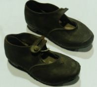 A pair of child's old leather clogs with button strap fastenings