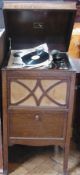 An HMV oak cased wind up gramophone, 78rpm, with record storage cupboard below, raised on square