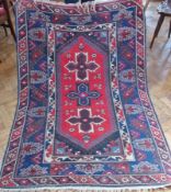 Persian style wool rug, cherry red ground with three geometric quatrefoil medallions, stylised
