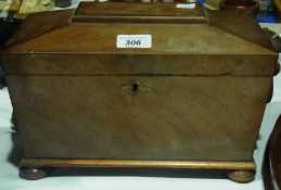 An early nineteenth century mahogany sarcophagus shaped tea caddy with ring handles, the interior