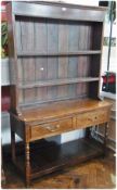 An early nineteenth century oak dresser, with two shelf open rack, two frieze drawers below on