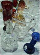 Cut glass water jug, a small cut glass decanter, a blue glass candlestick and a red and white