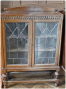 20th century oak glazed bookcase, with astragal glazed doors, enclosing three shelves on turned