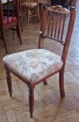 Two 20th century stained walnut spindleback chairs with stuffover seats on turned supports