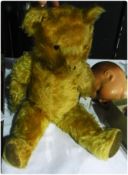 A gold plush teddy bear, an Armand Marseille bisque head doll, No, 518-7K, and a little black