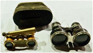 A pair of opera glasses in a leather case, together with another pair with handle
