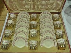 A Royal Doulton comprehensive coffee set, comprising twelve cups and saucers, with handpainted