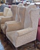 A pair of highback wing armchairs, on oak supports and rail (2)