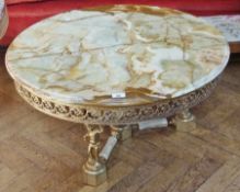 A circular topped onyx coffee table, with gilt metal foliate open fretwork frieze, raised on