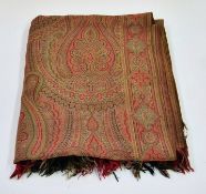 A large Paisley shawl in greens and reds with fringe, small repair to one corner