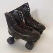 A pair child's black leather laced roller skates