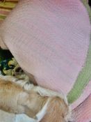 A large green and pink quilt, various linen cushion covers, various cushions, fur cushion, a small